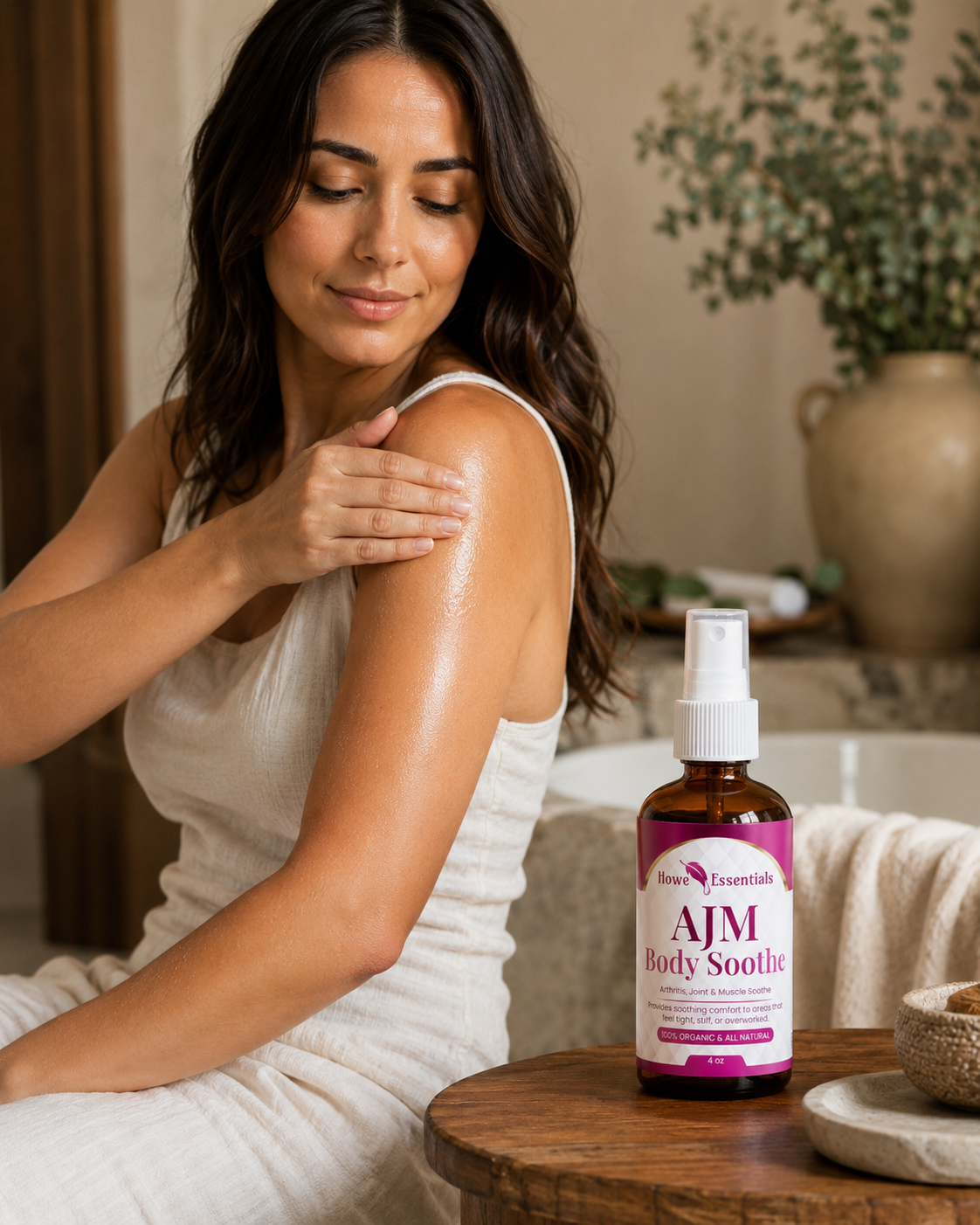 Woman massaging AJM Body Soothe oil into her shoulder